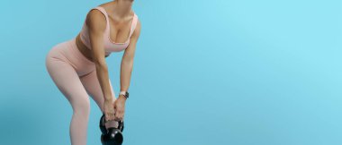 Güzel, atletik bir kadın elinde siyah, ağır bir kettlebell, fotokopi, uzay boşluğu...