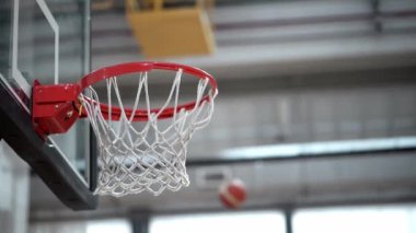 Basketbol topu halka boyunca kayarken ringe çarpar ve yavaş çekimde geri uçar. Salondaki spor salonuna git. Yüksek kaliteli FullHD görüntüler