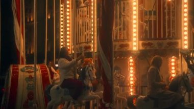 Genç ve güzel bir kız atlıkarıncaya binip selfie çekiyor. Ağır çekim. Moskova, Rusya, 09.23.2021