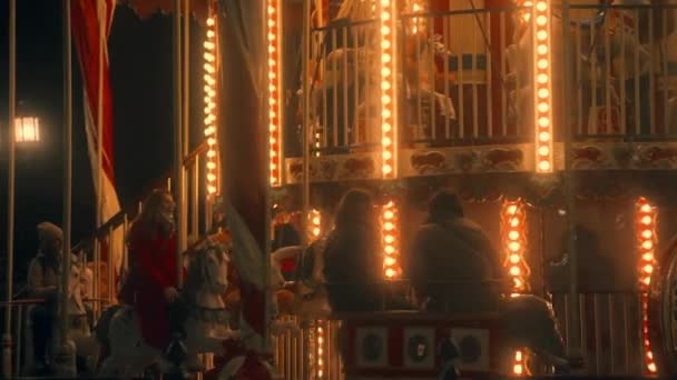 Young girl rides a pony and shakes her head to the music on the carousel. slow-mo. Moscow, Russia, 09.23.2021 — Stock Video