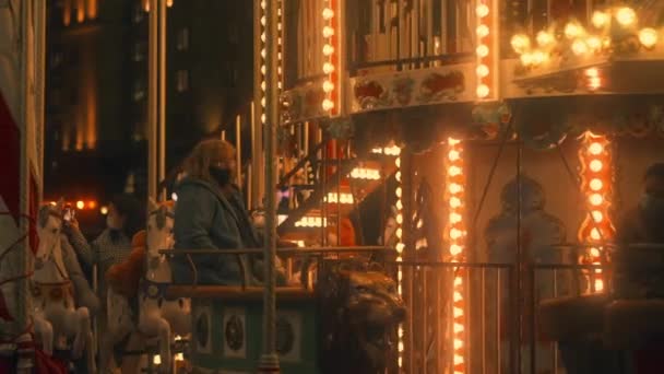 Maskerede mennesker ride en pony carousel.slow-mo. Moskva, Rusland, 09.23.2021 – Stock-video