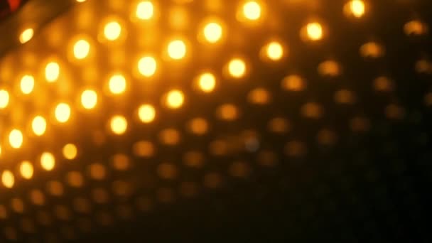 Vídeo de fundo com desfocado Luzes de lâmpada de projector laranja quente acender e desligar, matriz de luz em movimento. — Vídeo de Stock