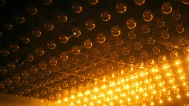 Vidéo de fond avec projecteur orange chaud non focalisé allume et éteint les lumières de l'ampoule, matrice de lumière mobile. — Video