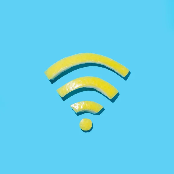 威菲符号概念与明亮的黄色柠檬皮切割成无线互联网形状的青蓝色背景 最小平铺 — 图库照片