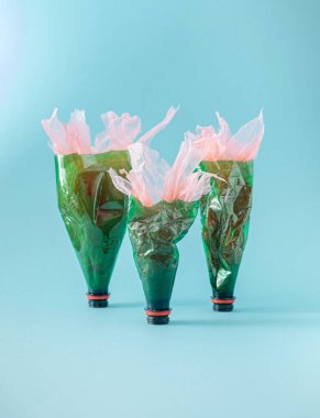 Üç geri dönüşümlü şişe plastik atık fikri için ganimet gibi dizilmiş.