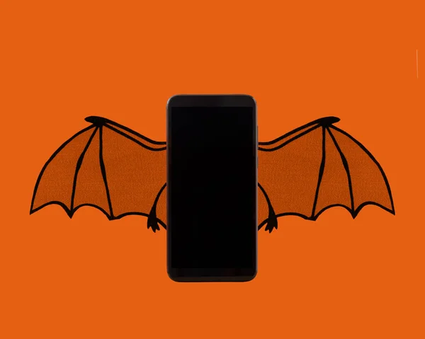 空白の携帯電話とともにバットウィング用オリジナルハロウィンモックアップアイデア ストック写真