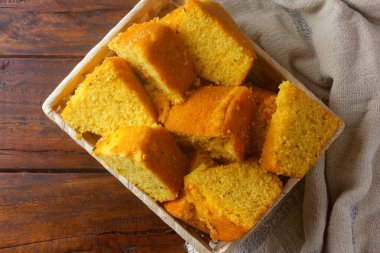 Mısır keki kahvaltıda kırsal ahşap masada sepetle dilimlenmiş. Tipik Brezilya yemekleri. Üst görünüm