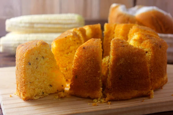 corn cake sliced on wooden board on rustic wooden table for breakfast. Typical Brazilian food. Front view. Selective focus