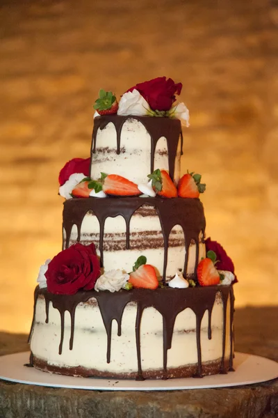 Свадебный торт украшен красными розами Стоковое Изображение