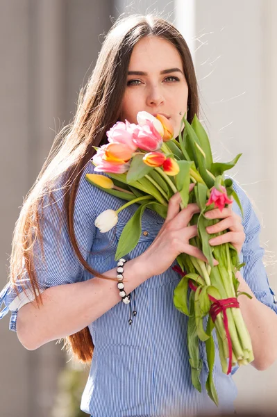 Porträt eines attraktiven Mädchens mit einem Strauß Tulpen — Stockfoto