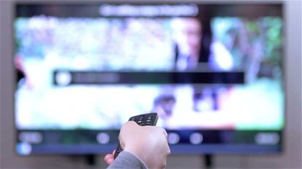 Hand wechselt die Kanäle auf Smart-TV-Fernbedienung. — Stockvideo