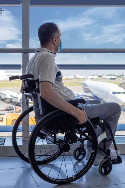 Jovem Com Máscara Protetora Uma Cadeira Rodas Aeroporto Olhando Pela — Fotografia de Stock