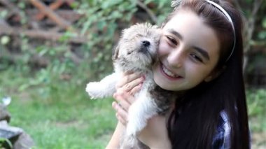 Kız açık havada bahçe içinde a köpek yavrusu sarılma