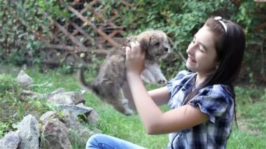 Kız açık havada bahçe içinde a köpek yavrusu sarılma