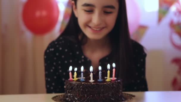 Chica joven soplando velas en pastel de cumpleaños — Vídeos de Stock