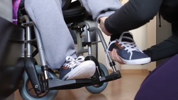 Aiutare un giovane disabile in sedia a rotelle — Video Stock