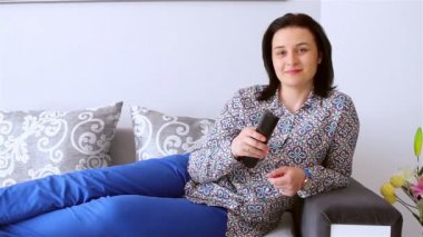 Televizyon izlerken uzaktan kumanda ile genç kadın