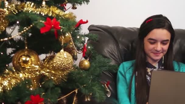 Genç kız Noel ağacı yakınındaki dijital tablet kullanma — Stok video