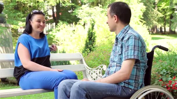 Homem com deficiência em cadeira de rodas e esposa conversando . — Vídeo de Stock