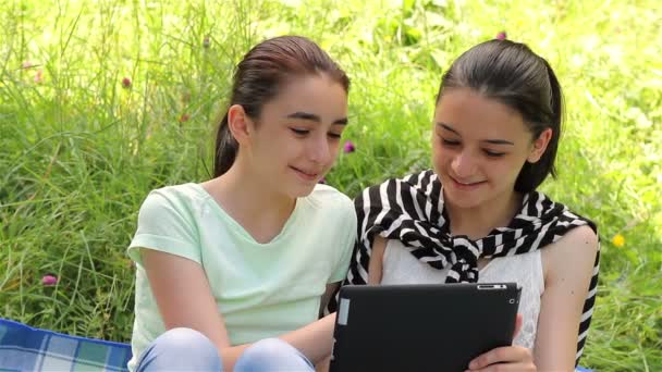 Дівчата грають на цифровому планшеті на відкритому повітрі — стокове відео