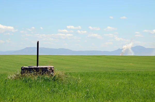 Landscape with a water well and fume — Stock Photo, Image