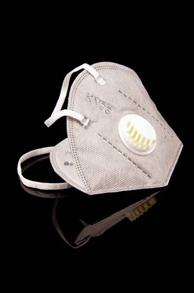 灰色の医療用マスクは 黒の反射背景に隔離されたウイルスやほこりの保護のためのKn95マーク — ストック写真
