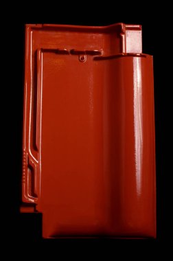 Siyah arkaplanda tek bir parlak kırmızı çatı fayansı izole edildi