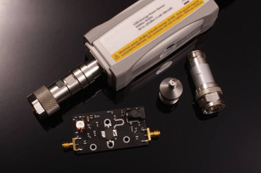 Kesin ölçümler için USB mikrodalga ve RF ortalama sinyal gücü ölçer ve siyah arkaplan üzerinde test altında RF yükseltici PCB izole