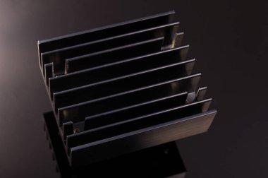 Siyah arka planda izole edilmiş alüminyum profilden yapılan yüksek güçlü elektronik soğutma için siyah ısıtıcı.