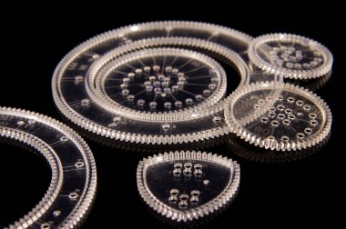 Eğitim için çeşitli eğriler çizmek için plastik spirograf aracı siyah yansıtıcı arka planda izole