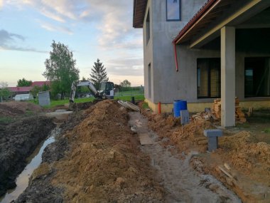 İnşaat alanında inşaat halindeki bireysel eve yakın drenaj kanalı