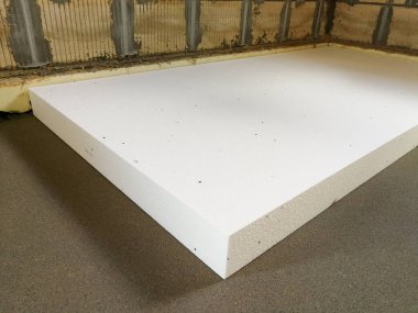 Sheet of expanded polystyrene on the concrete floor for house thermal insulation during constructions clipart