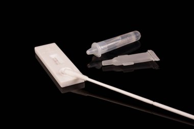 COVID-19 korona virüs tespiti ve salgın kontrolü için hızlı antijen test kiti siyah yansıtıcı arka planda izole edildi
