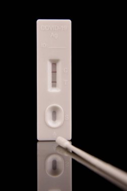 COVID-19 korona virüs tespiti ve salgın kontrolü için hızlı antijen test kiti siyah yansıtıcı arka planda izole edildi