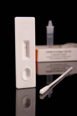 COVID-19 korona virüs tespiti ve salgın kontrolü için hızlı antijen test kiti siyah yansıtıcı arka planda izole edildi