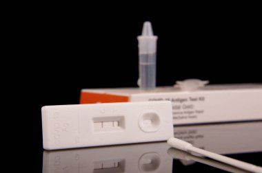 COVID-19 korona virüs tespiti ve salgın kontrolü için hızlı antijen test kiti siyah yansıtıcı arka planda izole edildi