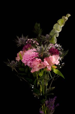 Siyah arka planda izole edilmiş pembe ve mor renkli çiçek buketi.