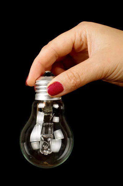 Mano femminile con lampadina isolata sullo sfondo nero — Foto Stock