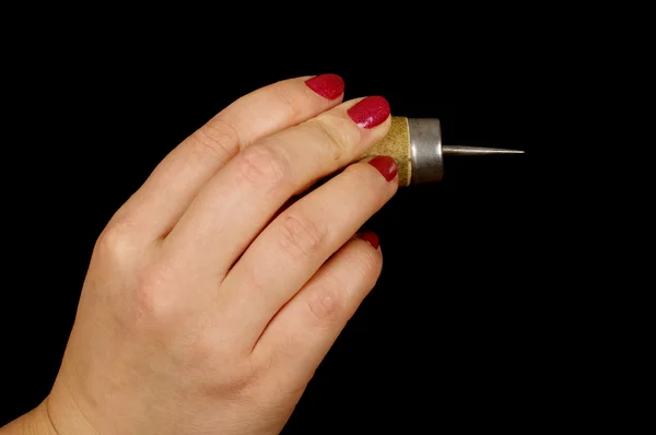 Женская рука держит шило, изолированное на черном — стоковое фото