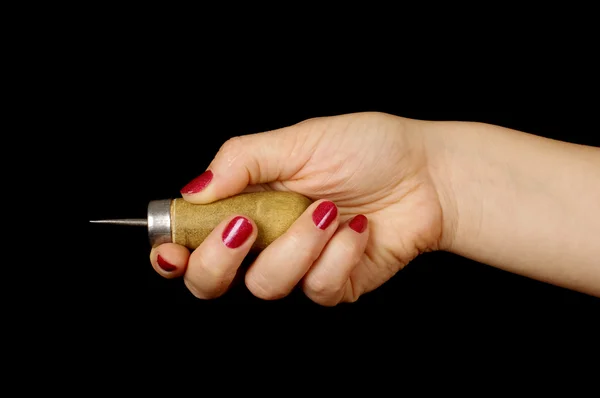 Woman hand holding awl isolated on the black — Stock Photo, Image