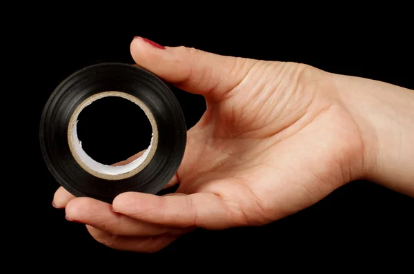 Woman hand holding black electric insulating tape — Stock Photo, Image