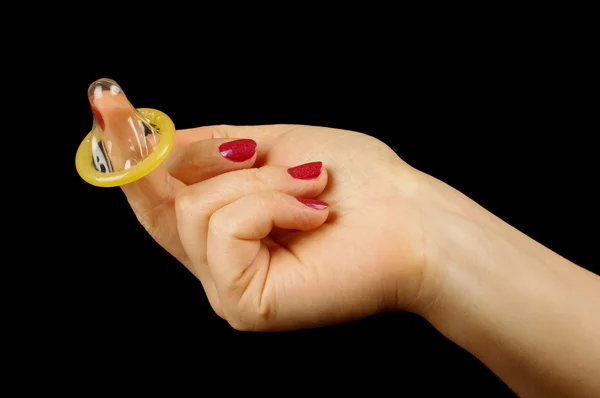 Hand holding condoom verpakt op de zwarte achtergrond — Stockfoto