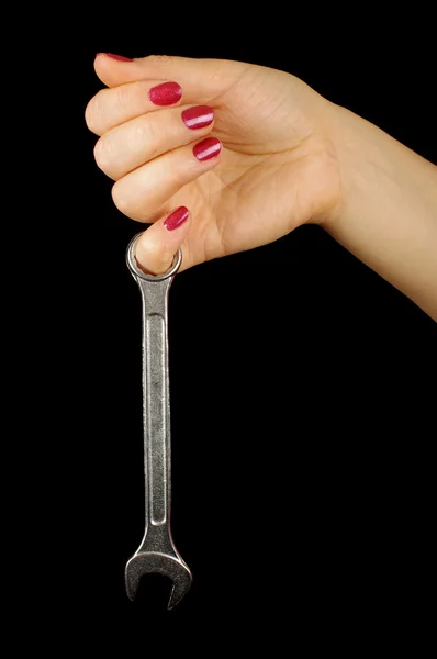 Female hand gently holding steel wrench on the black background — Stock Photo, Image