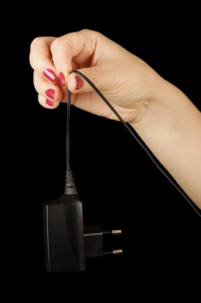 Woman hand hold black cell phone charger — Stock Photo, Image