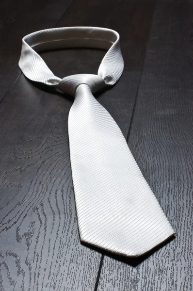 White tie on the wooden floor — Stock Photo, Image