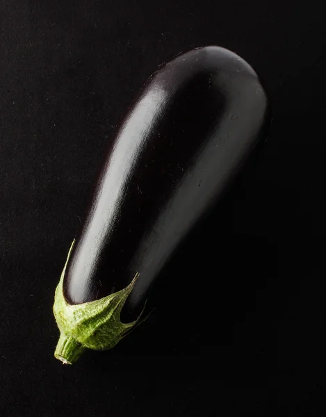 Aubergine isolerad på bakgrunden svart tyg — Stockfoto