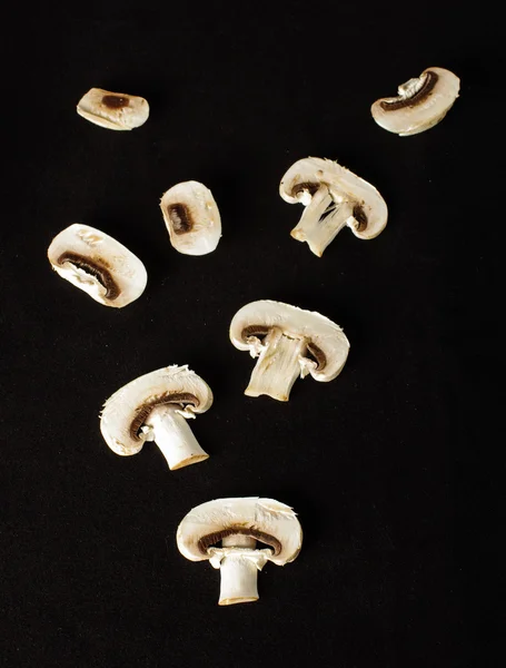 Raw champignon mushroom slices on the dark background — Stock Photo, Image