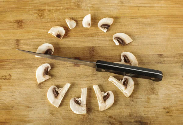Creative phototgraphy: slices of champignon mushroom and knife as a clock — Stock Photo, Image