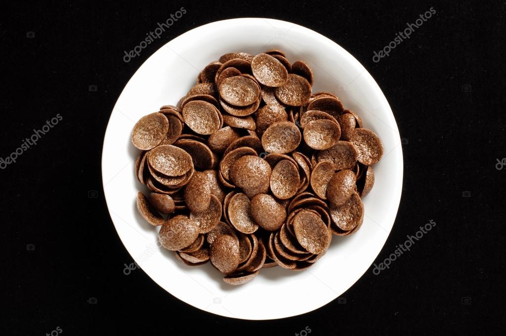 Bowl of chrispy chocolate crunch cornflakes isolated on the black background