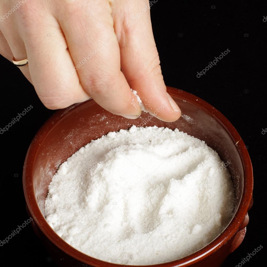 Female hand holding pinch of salt